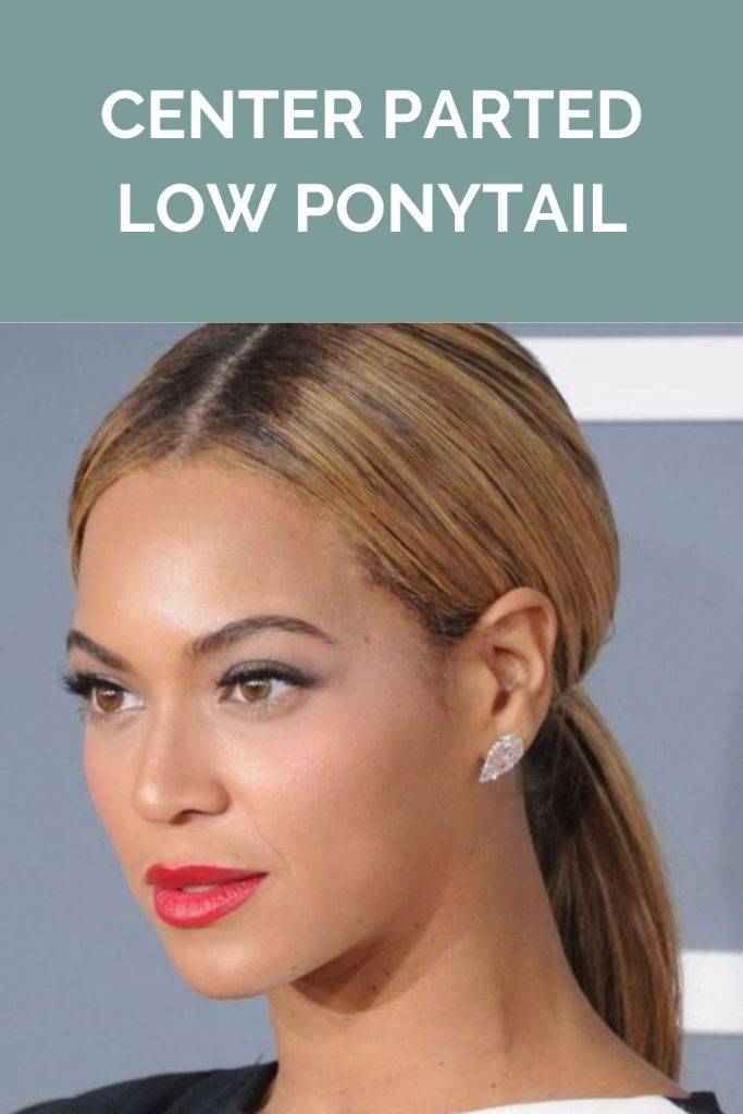 A girl with black lipstick and stud earrings showing her center parted low ponytail - ponytail hairstyle