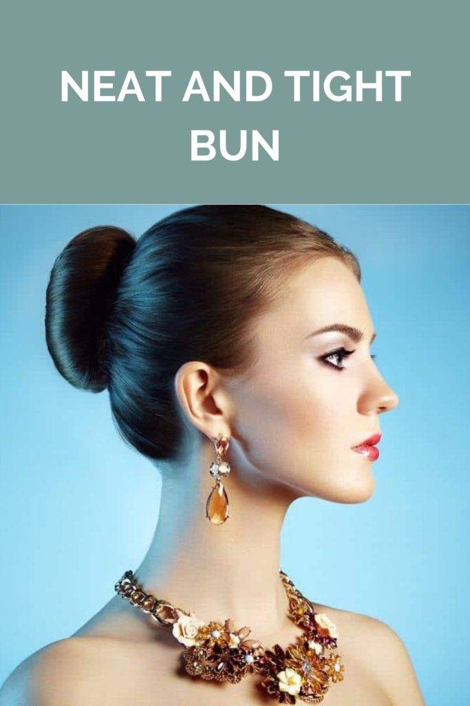 A girl in heavy necklace with matching earrings showing the side view of her neat and tight bun - 20s women hairstyle