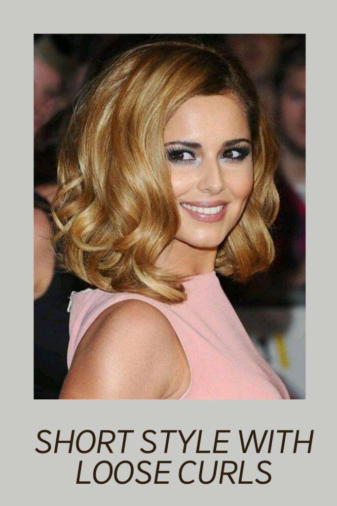 A girl in pink dress smiling and posing for camera and showing her Short Style With Loose Curls - hairstyles for short hair