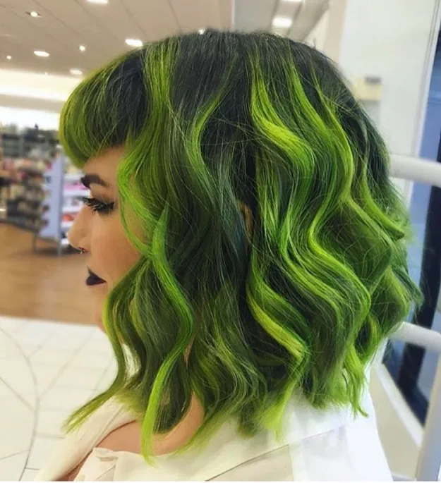 A girl in white top showing the side view of her lime green highlights - green hair color