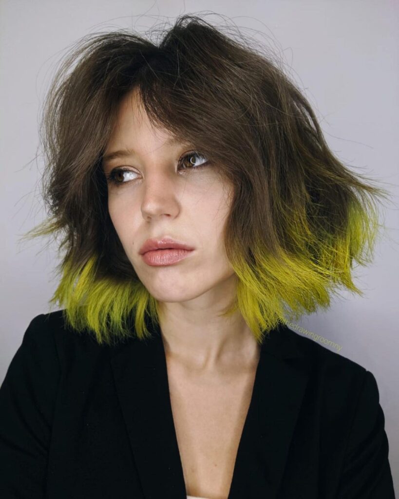 A girl in black black coat showing her	Dip-dye hair color - green hair color for women
