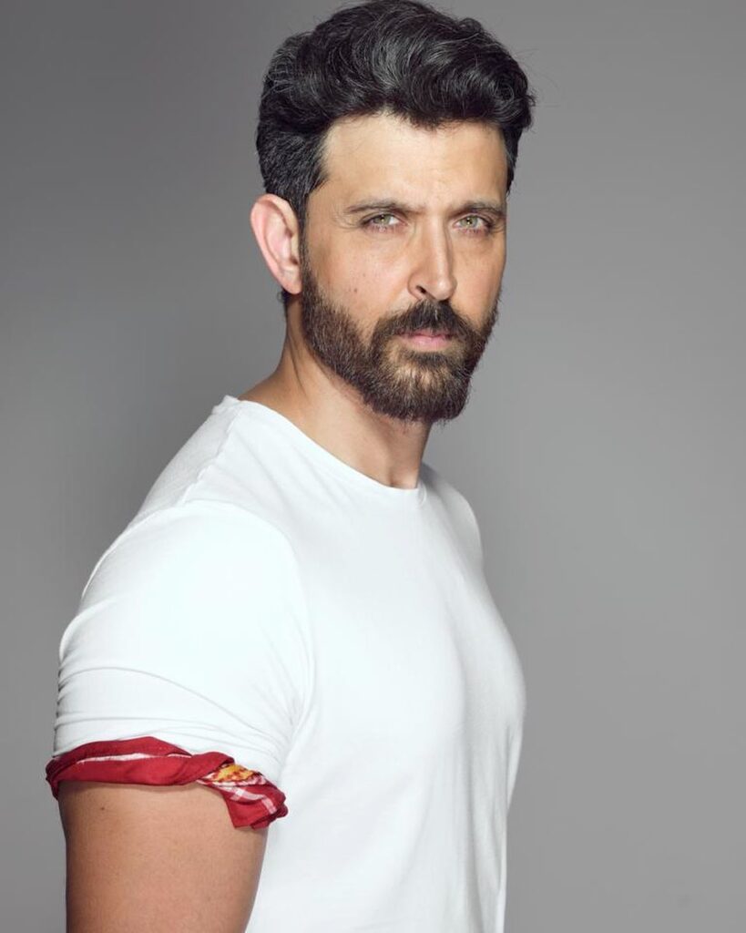 Hrithik Roshan in white t-shirt posing for camera and showing his faux hairstyle - hrithik roshan war hairstyles