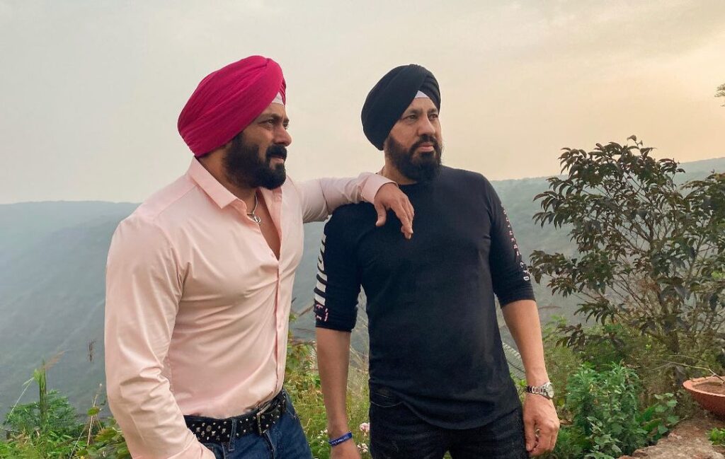 Salman Khan in peach color shirt with red turban posing for camera with his body guard - Salman khan long hairstyle 