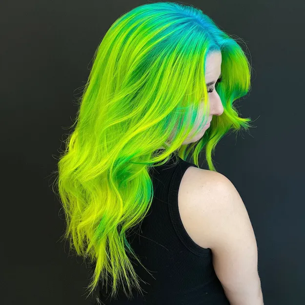 A girl in black cut sleeves top showing the side view of her Neon green hair fade - green hair color for women