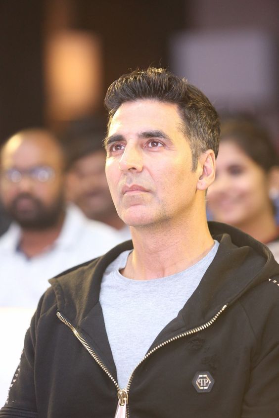 Akshay Kumar in grey t-shirt with black jacket posing for camera and showing his undercut hairstyle - sooryavanshi akshay kumar hairstyle