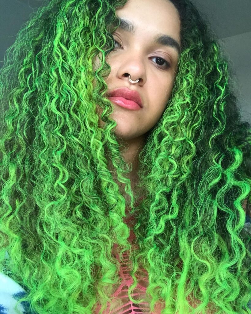 A girl in pink lipstick and nose ring showing her lime frost hair color - green hair color