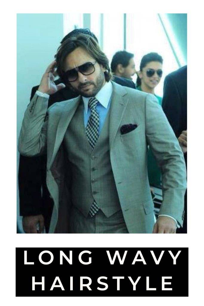 Saif Ali Khan in grey suit with check tie and goggles posing for camera and showing his long wavy hairstyle - saif ali khan latest hairstyle