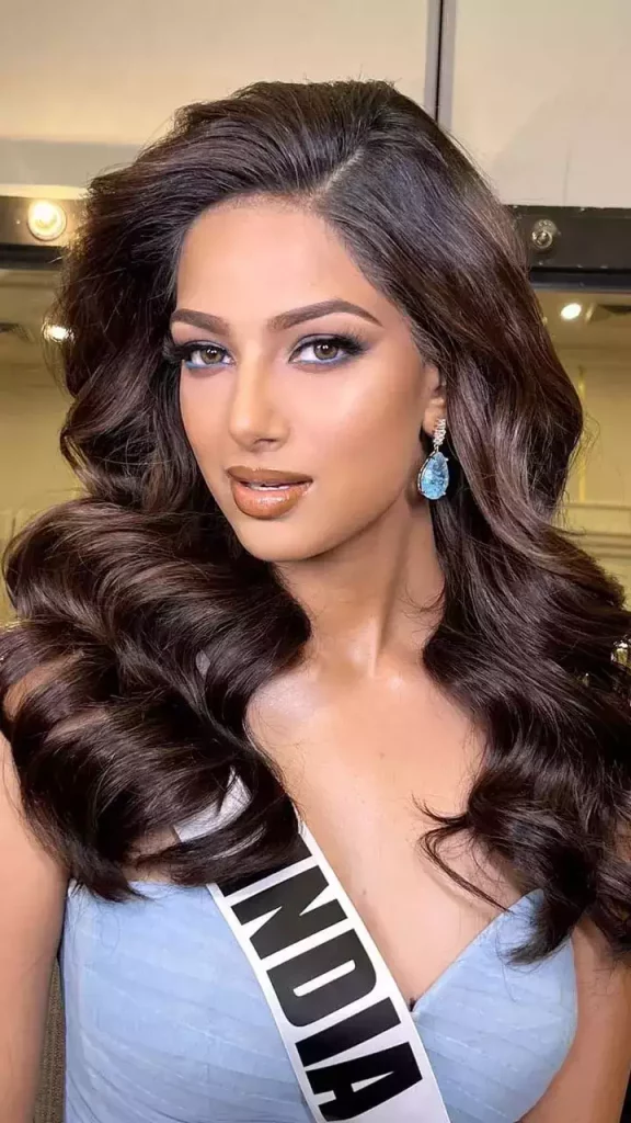 Harnaaz Sandhu in sky blue deep neck dress with matching earrings posing for camera and showing her  light waves hairstyle - miss universe harnaaz sandhu