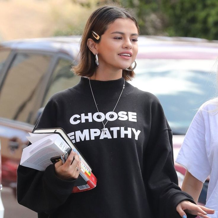 Selena Gomez in black high neck sweatshirt posing for camera and showing her choppy chin-grazing cut - hairstyles of hollywood actresses