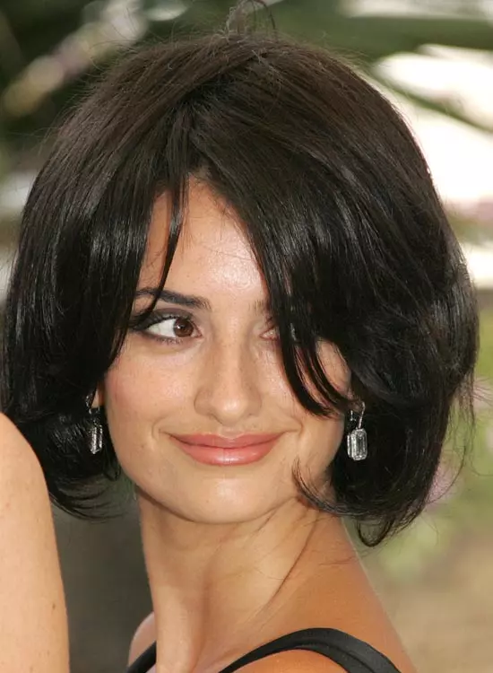 Smiling Penelope Cruz in black strappy dress posing for camera and showing her chop bob - hollywood actress hairstyle