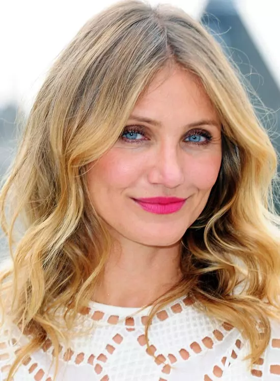 Smiling Cameron Diaz in white dress with pink lipstick posing for camera and showing her wavy overgrown bob cut - hairstyles of hollywood actresses