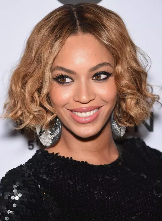 Beyonce in black shimmery dress with matching danglers posing for camera and showing her long wavy tresses - hollywood actresses hairstyles