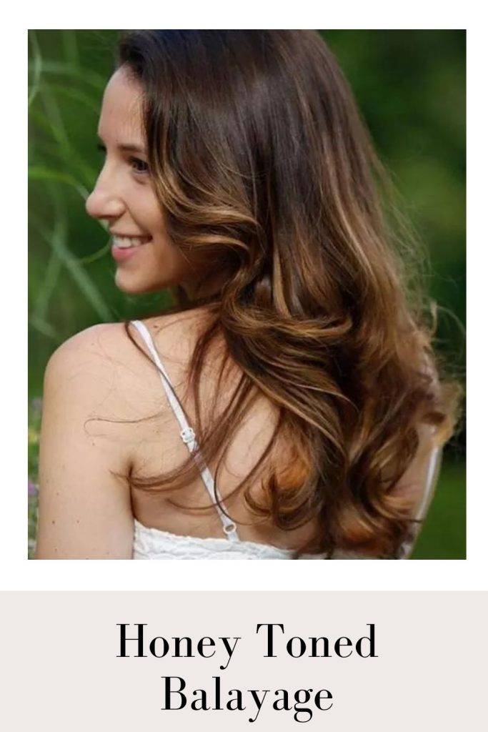 A girl in white strappy dress showing the side view of her Honey Toned Balayage - golden hair color highlights