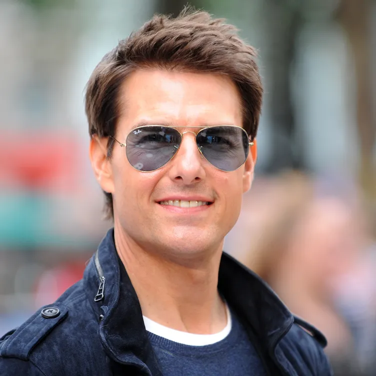 Smiling Tom Cruise in blur t-shirt and jacket with matching goggles - Dental Implants