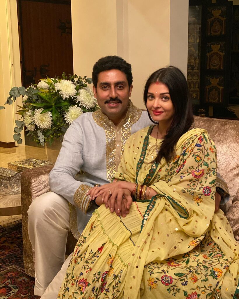 Abhishek Bachchan in grey and golden kurta and Aishwarya Rai in yellow suit sitting on couch and posing for camera - facts for February Born 