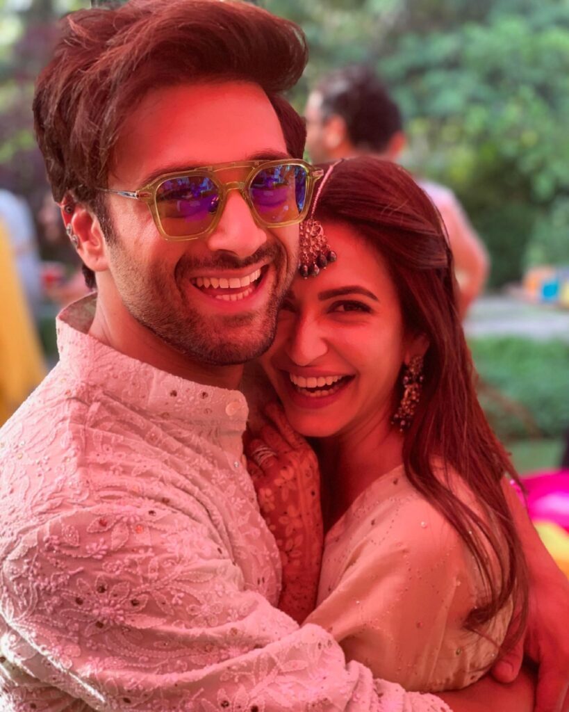 Smiling Pulkit Samrat and Kriti Kharbanda in pink matching outfit hugging each other and posing for camera - Capricorn compatibility for love