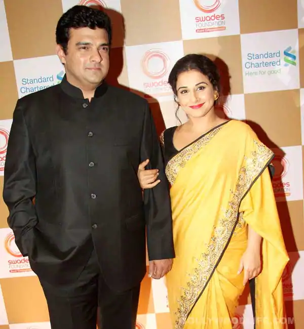 Vidya Balan in yellow saree and Siddharth Roy Kapur in black suit posing for camera - Capricorn perfect match