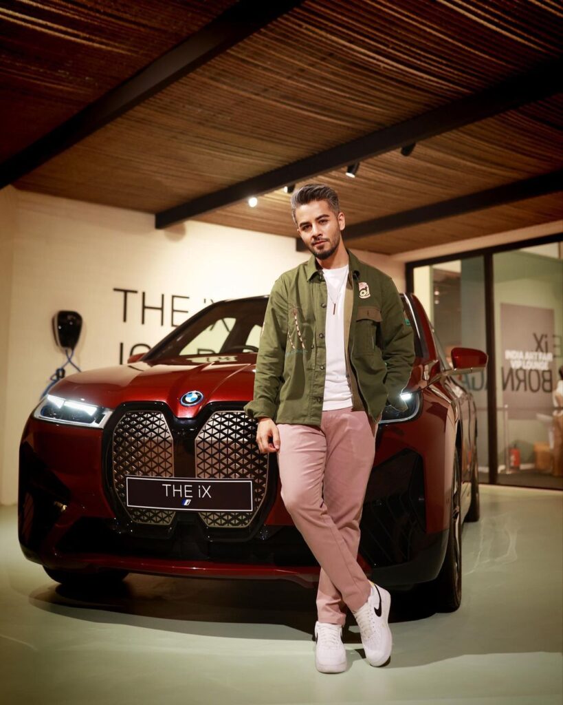 Abhinav Mathur in pink trouser with green jacket and white t-shirt posing for camera in front of a car - male models of India