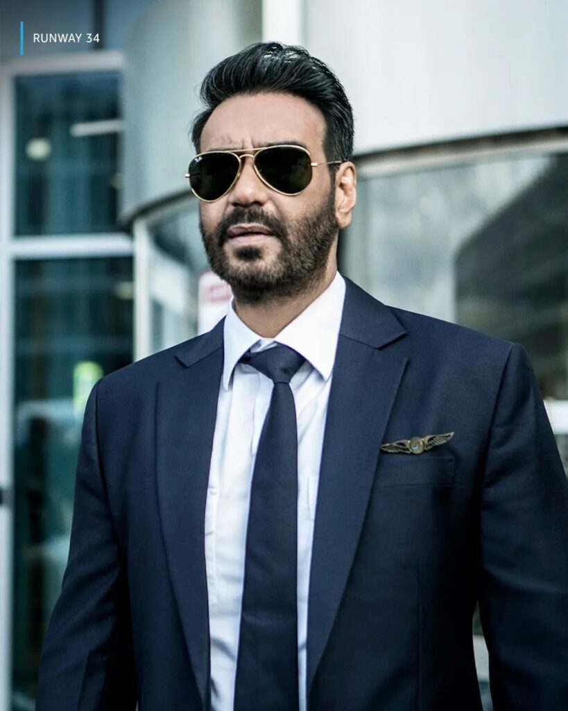 Ajay Devgan in blue suit with white shirt  and goggles posing for camera - Bollywood celebrities hairstyles