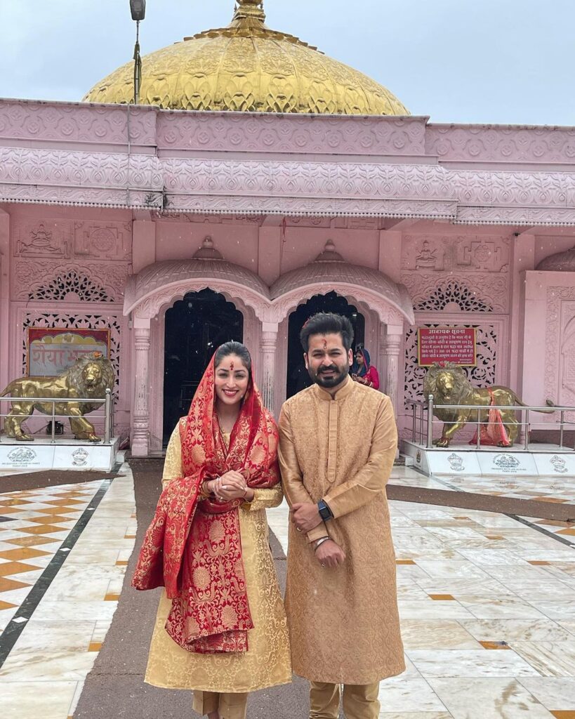 Yami Gautam and Aditya Dhar in traditional Indian attire standing in front of a temple - Sagittarius perfect match