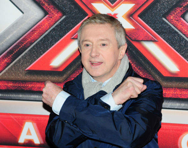 Louis Walsh in blue jacket with grey scarf posing for camera - dental implants hollywood celebrities