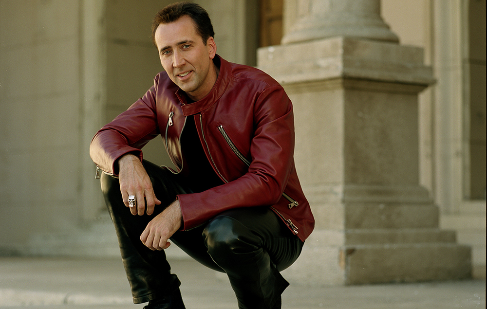Nicolas Cage in black pant with maroon jacket posing for camera - Dental Implants