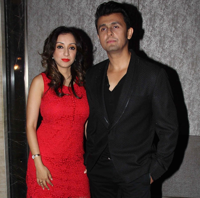 Sonu Nigam in black suit and  Madhurima in red dress posing for camera - Leo compatibility