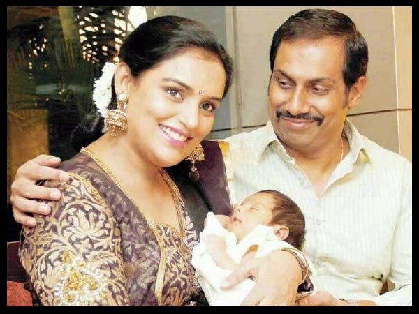 Shweta Menon in brown and golden saree holding her baby in her arms  Sreevalsan Menon in white lining shirt posing for camera - Taurus compatibility signs