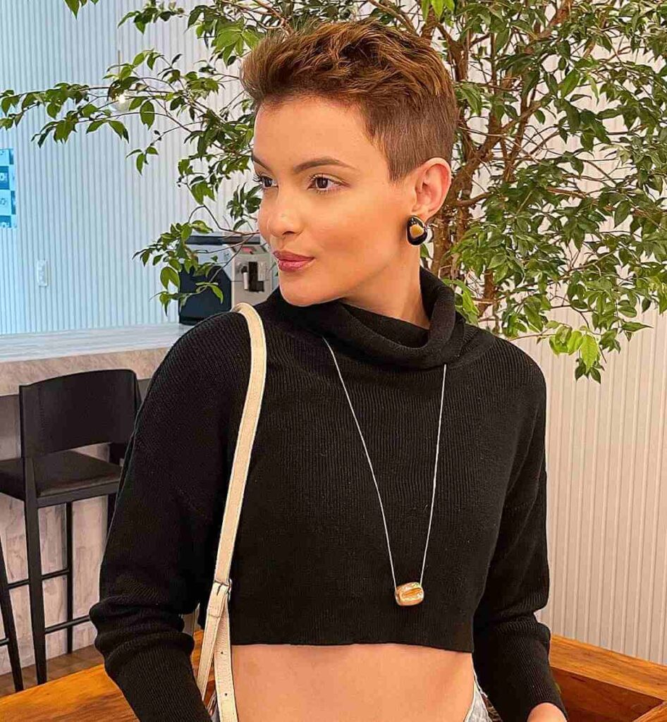 Woman in black crop top with necklace and purse showing her Very short messy hair - hairstyles for long face