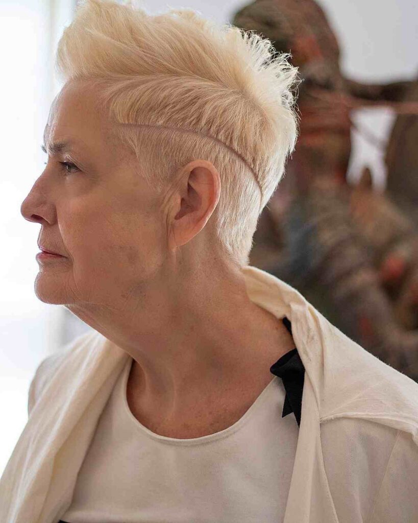 A mature woman in white dress and Edgy pixie with hard part and undercut - trending haircut images