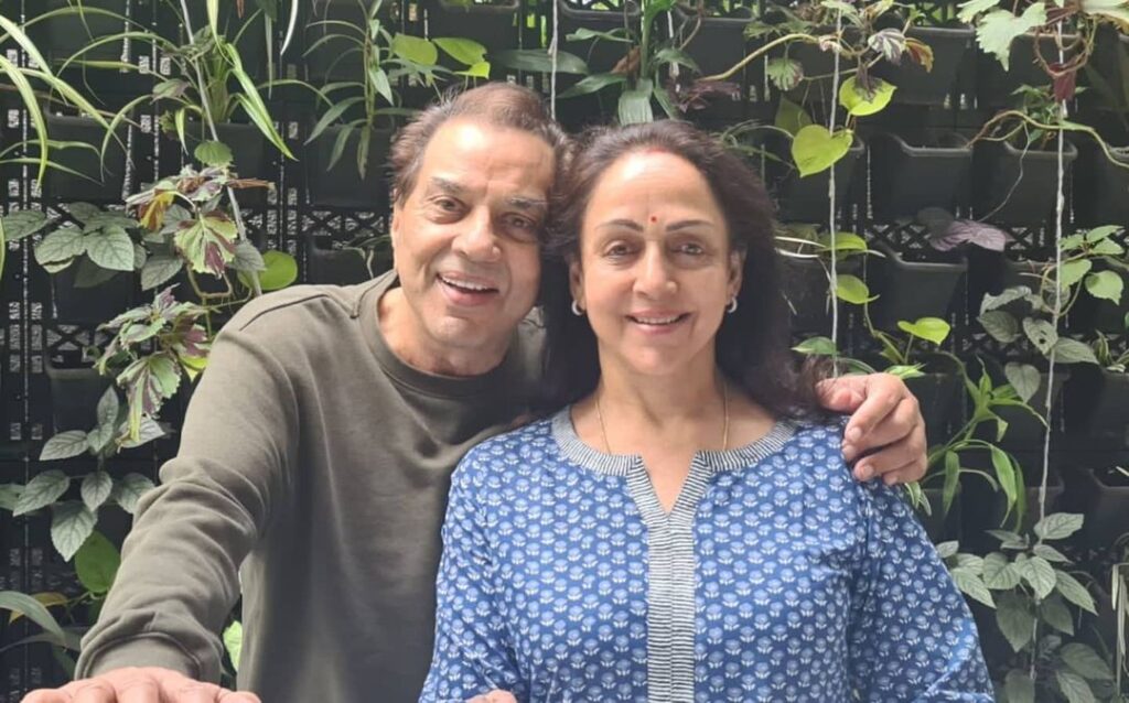 Hema Malini in blue and white printed kurta and Dharmendra in grey gull sleeves t-shirt posing for camera - best match for Libra