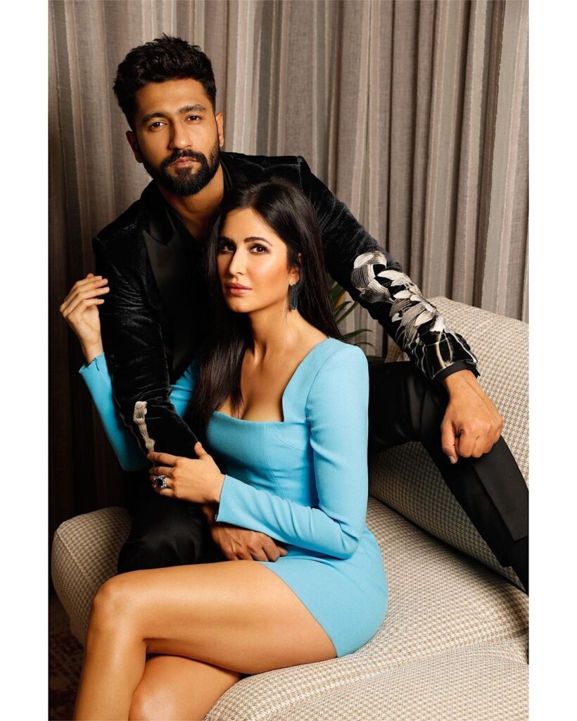 Vicky Kaushal in black suit and Katrina Kaif in sky blue short dress sitting on a couch - Taurus compatibility 