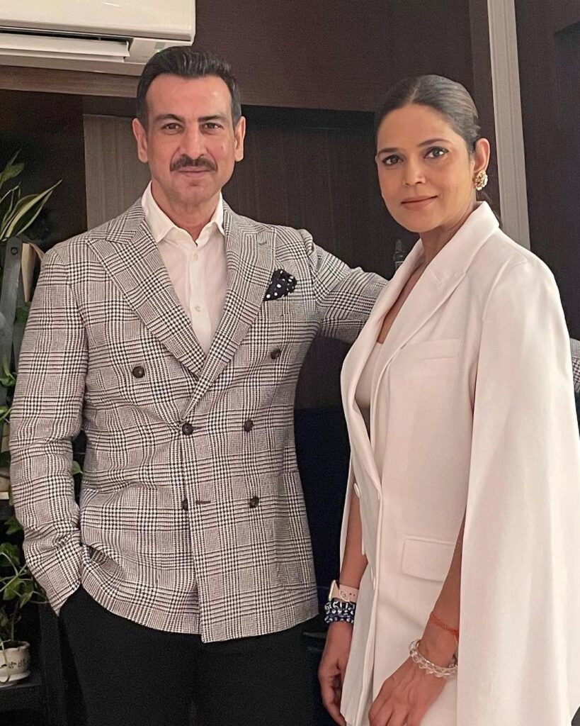 Ronit Roy in check coat with white shirt and Neelam in white coat dress posing for camera - facts for October Born