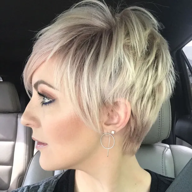 Woman in black top a and silver earrings showing her Disconnected Blonde Balayage haircut - short hairstyles ladies