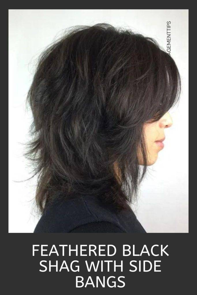Woman in black dress showing the side view of her feathered black shag with side bangs - shaggy haircuts 2022