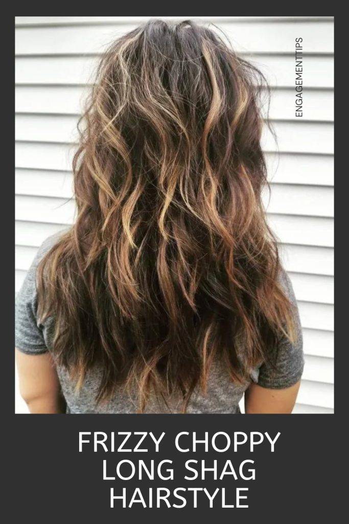 Woman in grey t-shirt showing the back view of her frizzy choppy long hairstyle - short haircut 