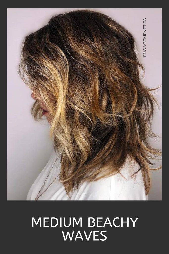 Woman in white shirt and medium beachy waves - shag haircuts with bangs