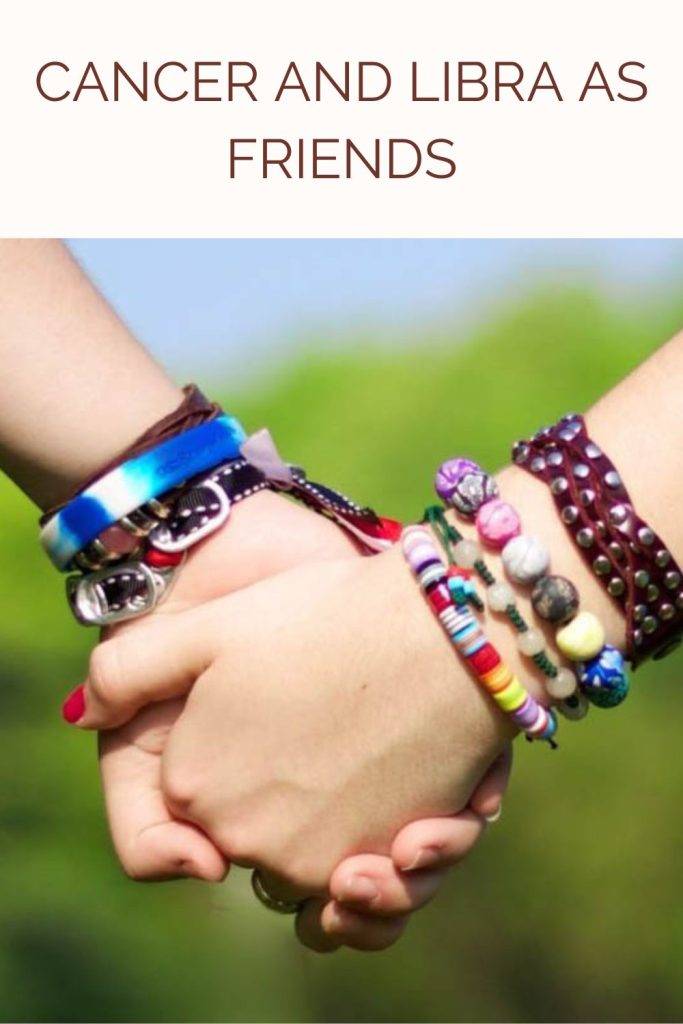 Two friends are holding each others hands - Cancer and Libra compatibility friendship