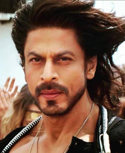 Shahrukh khan in in black and white attire with long hair and neat beard 