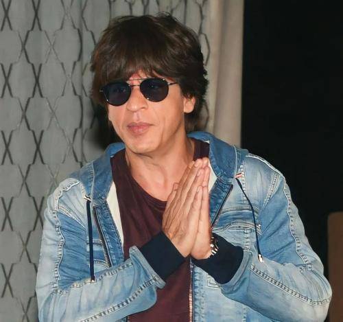 Shahrukh khan in blue denim jacket with black t-shirt and goggles with messy hairstyle