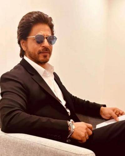 Shahrukh khan in black suit with white shirt and slicked back medium hairstyle