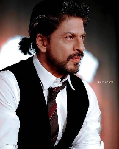 Shahrukh khan in white shirt with black waist coat with ponytail