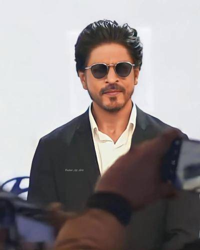 Shahrukh khan in black suit with white shirt goggles and gelled hair