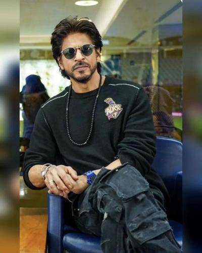 Shahrukh khan in black t- shirt with goggles and wet medium hairstyle
