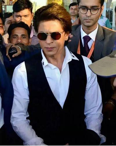 Shahrukh khan in white shirt with black waist coat and medium hairstyle