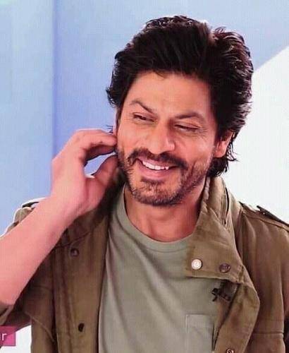 Shahrukh khan in brown shirt with grey t-shirt and side parted medium hairstyle