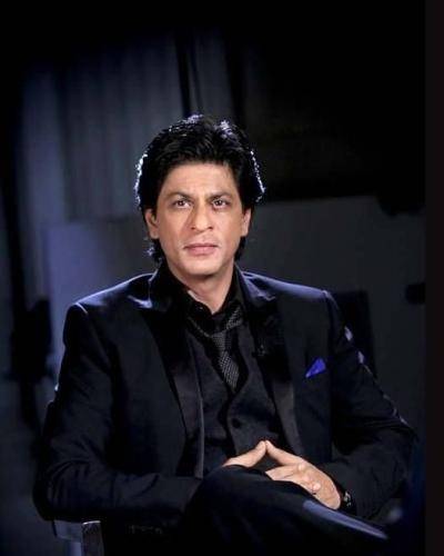 Shahrukh khan in black outfit and side parted medium hairstyle