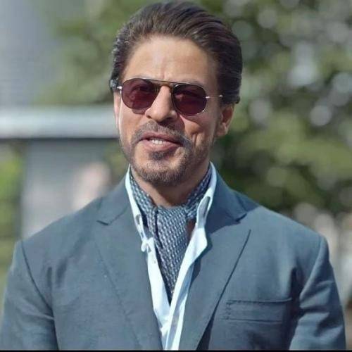 Shahrukh khan in blueish suit with ponytail hairstyle