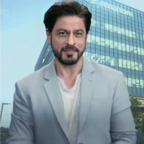 Shahrukh khan in grey coat with white t-shirt and medium slicked back hairstyle with beard